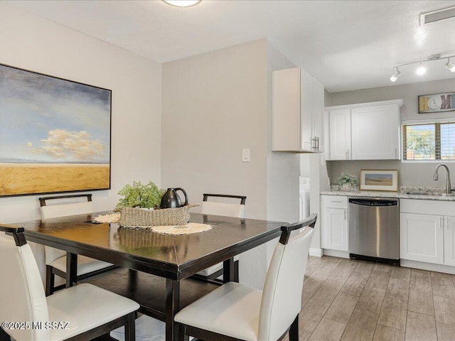 dining space with sink and light hardwood / wood-style flooring