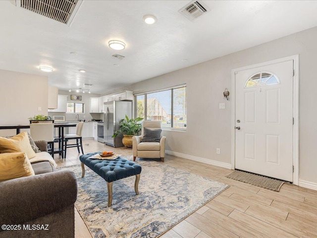 living room featuring sink and light hardwood / wood-style floors