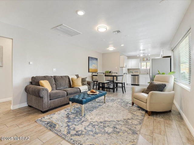 living room with sink and light hardwood / wood-style floors