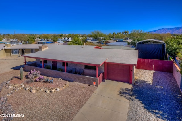 pueblo-style house featuring a garage, a mountain view, and concrete driveway