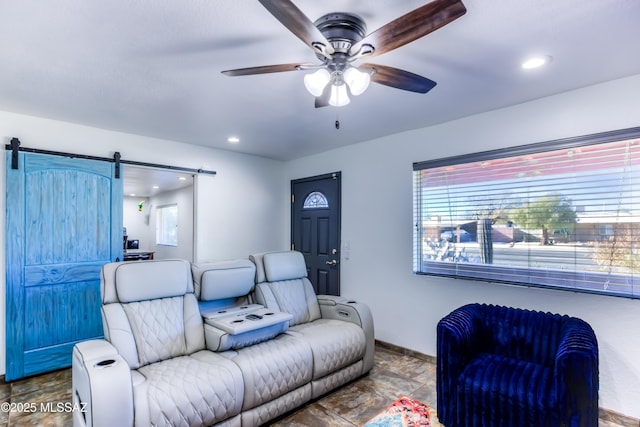 living room with ceiling fan, a barn door, recessed lighting, and baseboards