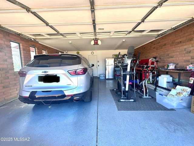 garage featuring a garage door opener and freestanding refrigerator