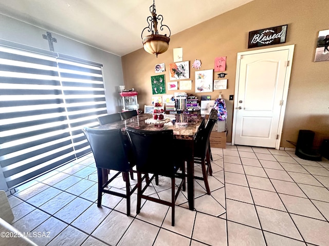 dining room featuring light tile patterned floors and vaulted ceiling