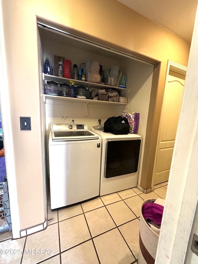 washroom with laundry area, light tile patterned flooring, and washing machine and dryer