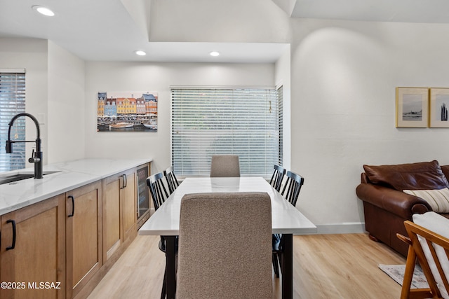 dining room featuring sink, a wealth of natural light, and light wood-type flooring