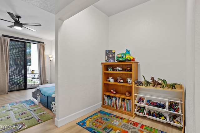 playroom with ceiling fan and wood-type flooring