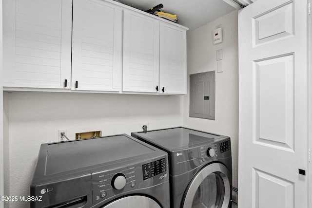 washroom featuring cabinets, electric panel, and washing machine and dryer