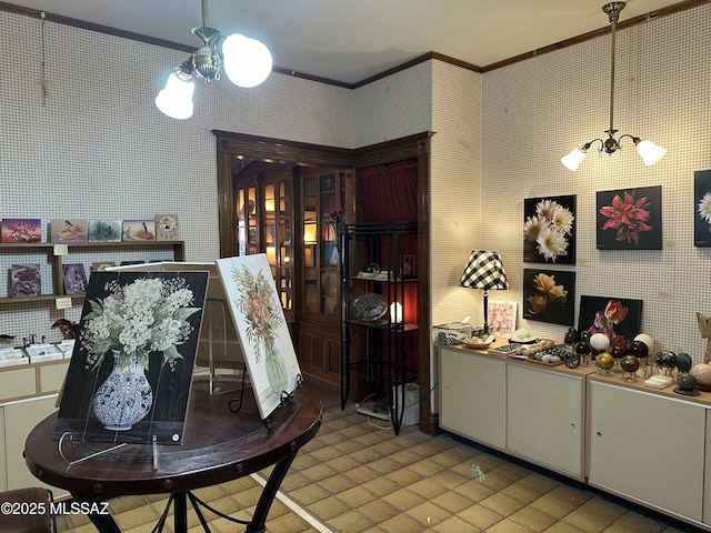 interior space with a chandelier, ornamental molding, and wallpapered walls