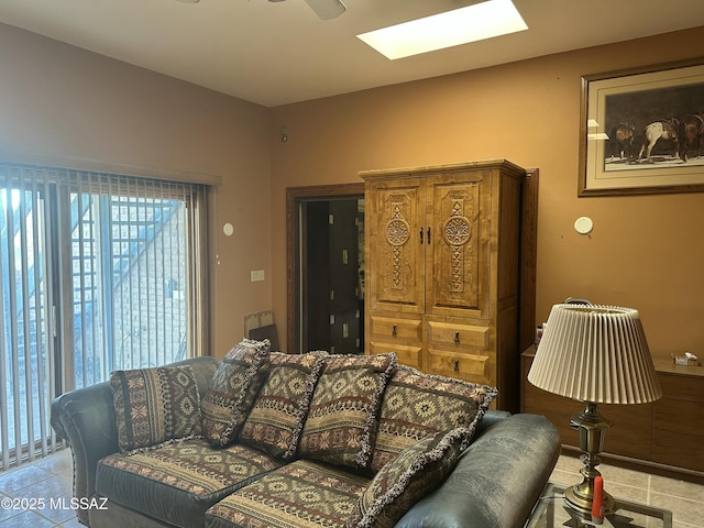 living room with a skylight and light tile patterned flooring