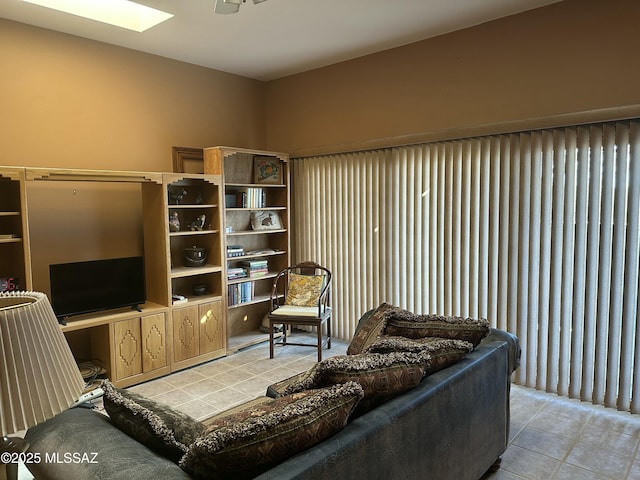 living area featuring light tile patterned floors and a skylight