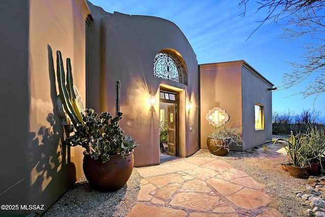 view of exterior entry with a patio