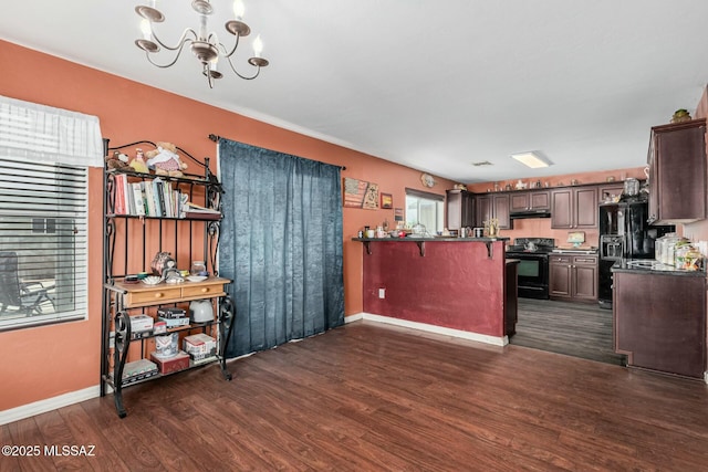 kitchen with a breakfast bar area, dark brown cabinets, dark hardwood / wood-style floors, black appliances, and a chandelier