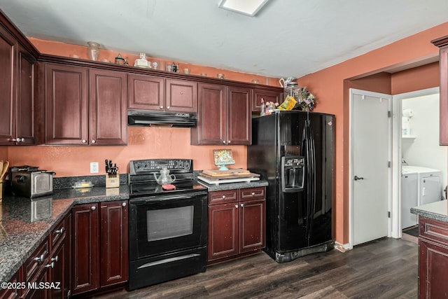 kitchen featuring dark stone counters, dark hardwood / wood-style floors, washer and dryer, and black appliances