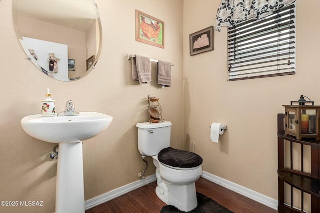 bathroom with hardwood / wood-style flooring and toilet