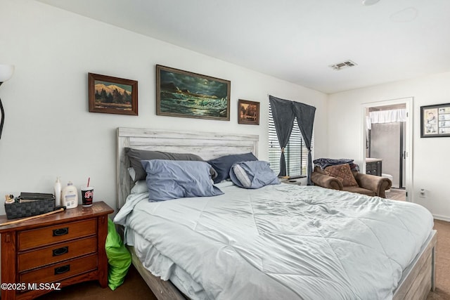 bedroom with ensuite bathroom and dark carpet