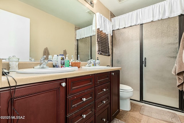 bathroom with tile patterned flooring, vanity, toilet, and walk in shower