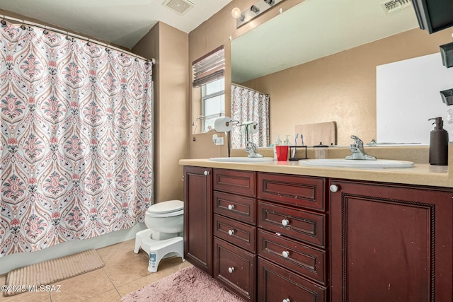 bathroom featuring vanity, tile patterned floors, and toilet