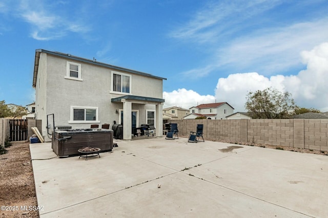 rear view of house featuring a hot tub, central AC unit, and a patio area