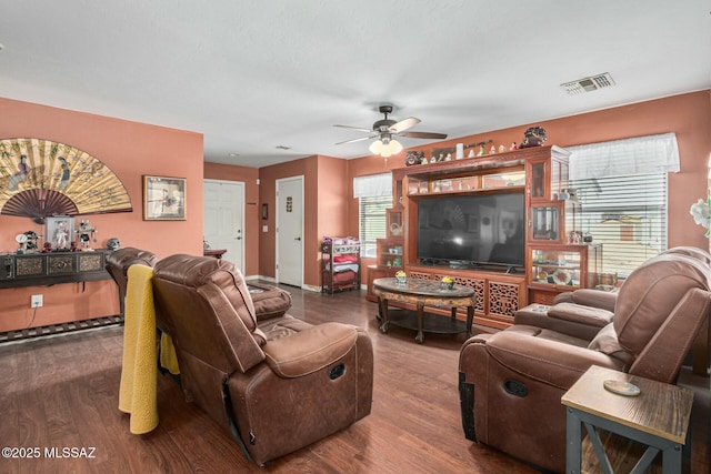 living room featuring dark wood-type flooring and ceiling fan