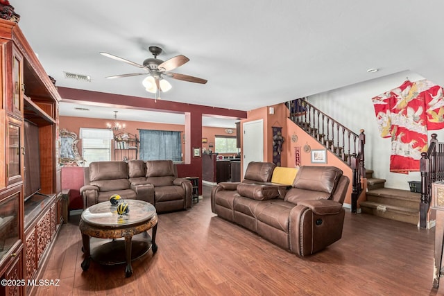 living room featuring wood-type flooring, ceiling fan with notable chandelier, and a wealth of natural light