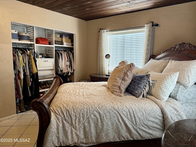 bedroom with light tile patterned floors, a closet, and wooden ceiling