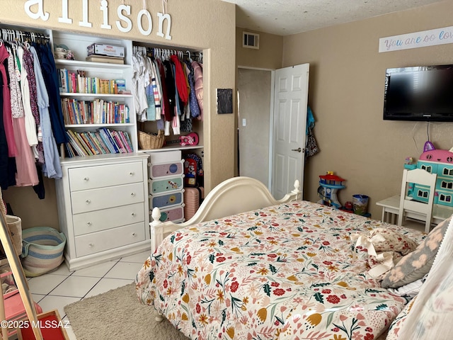 bedroom featuring light tile patterned flooring and a textured ceiling