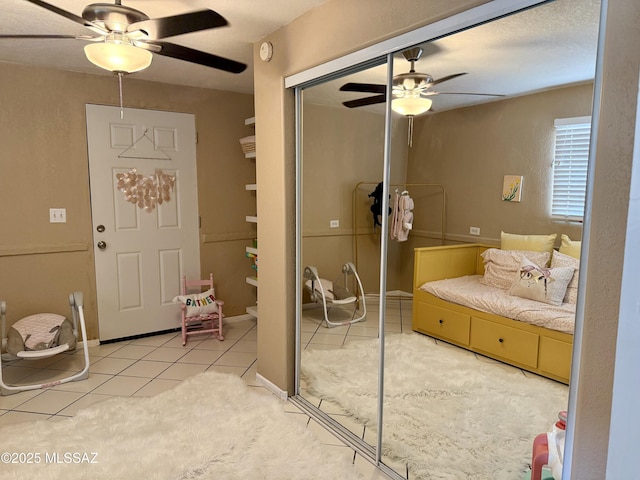 bedroom featuring tile patterned floors, ceiling fan, and a closet