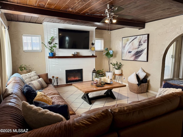 living room with wood ceiling, light tile patterned flooring, and beamed ceiling