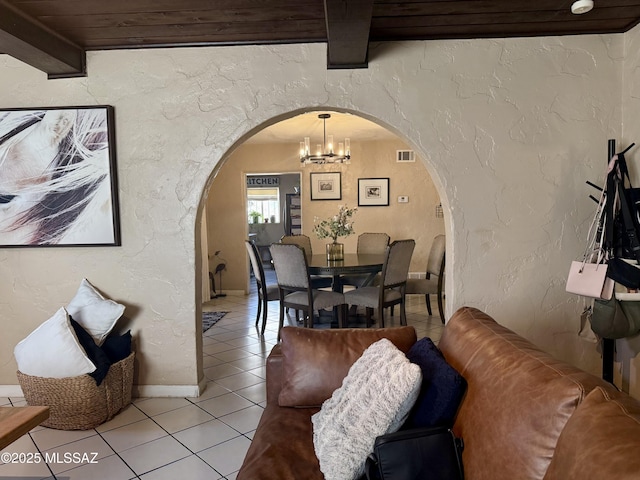 tiled dining room featuring a chandelier and beamed ceiling