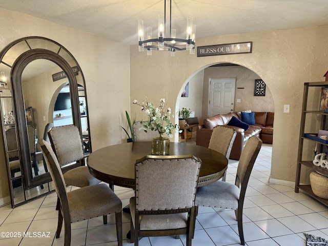 tiled dining space featuring an inviting chandelier