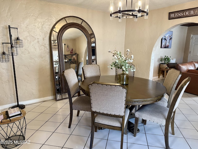 dining space with light tile patterned flooring and a chandelier