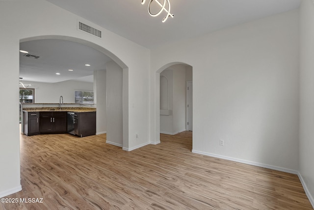 kitchen with visible vents, a sink, baseboards, light wood-type flooring, and stainless steel dishwasher