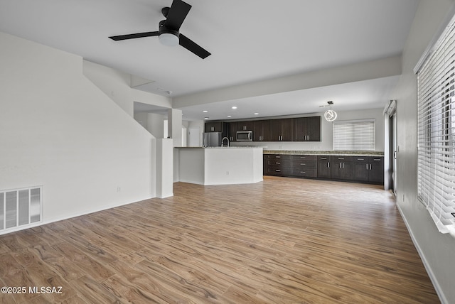 unfurnished living room featuring visible vents, baseboards, recessed lighting, light wood-style floors, and a ceiling fan