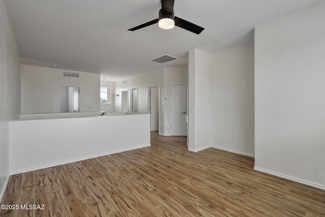 unfurnished living room featuring visible vents, baseboards, a ceiling fan, and wood finished floors