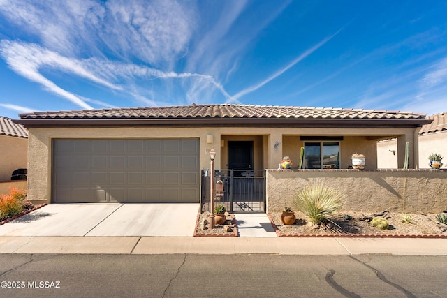 view of front of home featuring a garage, concrete driveway, and stucco siding