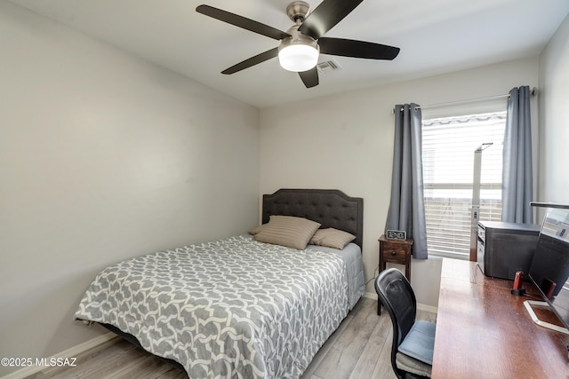 bedroom featuring baseboards, ceiling fan, visible vents, and light wood finished floors