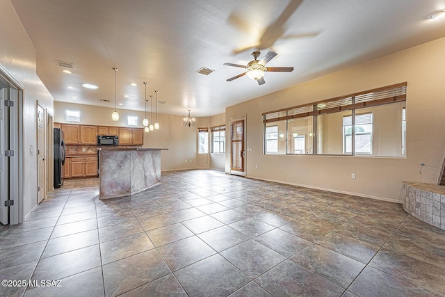 kitchen with pendant lighting, black appliances, decorative backsplash, dark tile patterned flooring, and ceiling fan with notable chandelier