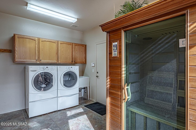 clothes washing area featuring cabinets, washing machine and dryer, and sink