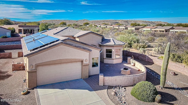 view of front facade with a garage, a mountain view, and solar panels