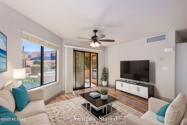 living area with ceiling fan, wood finished floors, and visible vents