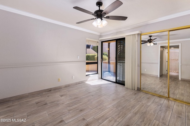 spare room featuring light wood-type flooring, baseboards, ornamental molding, and ceiling fan