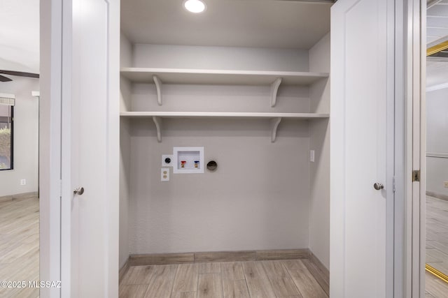 laundry area with laundry area, baseboards, light wood-style flooring, hookup for a washing machine, and electric dryer hookup