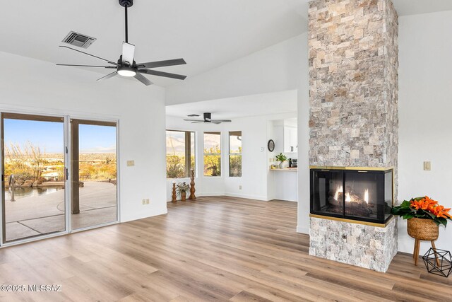 4725 N Placita De Concha, Tucson, AZ 85745 - unfurnished living room with a ceiling fan, wood finished floors, a fireplace, high vaulted ceiling, and baseboards