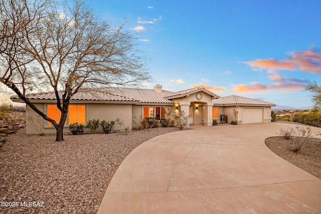 4725 N Placita De Concha, Tucson, AZ 85745 - mediterranean / spanish house with stucco siding, a tile roof, a garage, and a chimney