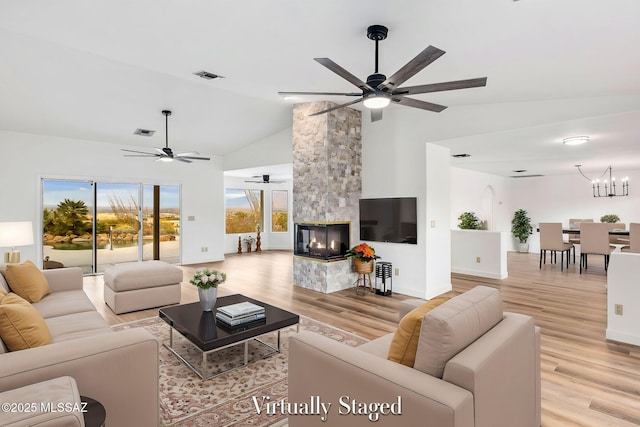 4725 N Placita De Concha, Tucson, AZ 85745 - living room with a ceiling fan, light wood-type flooring, high vaulted ceiling, a multi sided fireplace, and baseboards