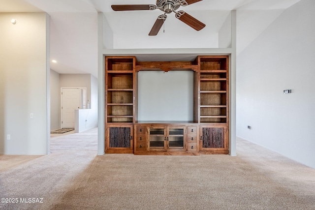 unfurnished living room featuring light carpet, ceiling fan, and built in shelves