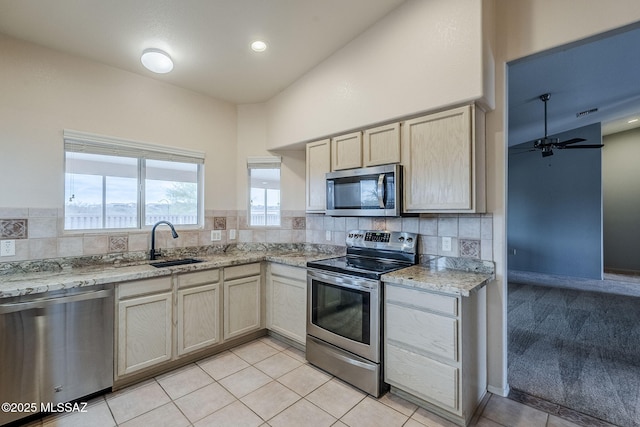 kitchen featuring sink, light tile patterned floors, ceiling fan, stainless steel appliances, and tasteful backsplash