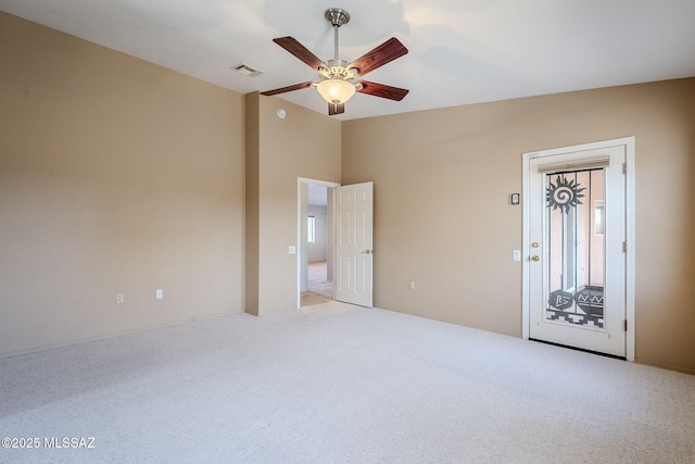 carpeted spare room featuring vaulted ceiling and ceiling fan