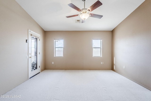 spare room with a healthy amount of sunlight, light carpet, and ceiling fan