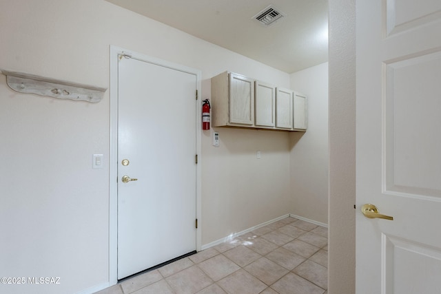 clothes washing area with light tile patterned floors